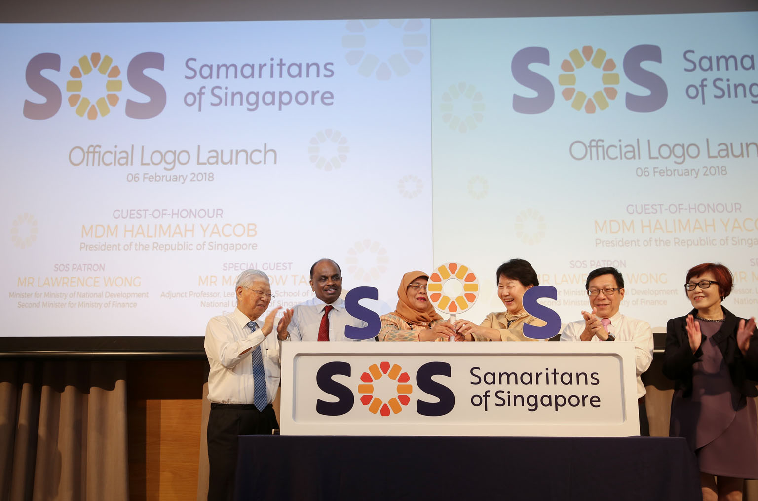President Halimah Yacob, and Samaritans of Singapore chairman Lee Sook Fung launching the centre's new logo yesterday. With them are (from far left) former board member Philbert Chin, vice-chairman Chinnatamby Nandakumar, Mr Mah Bow Tan and Ms Christ