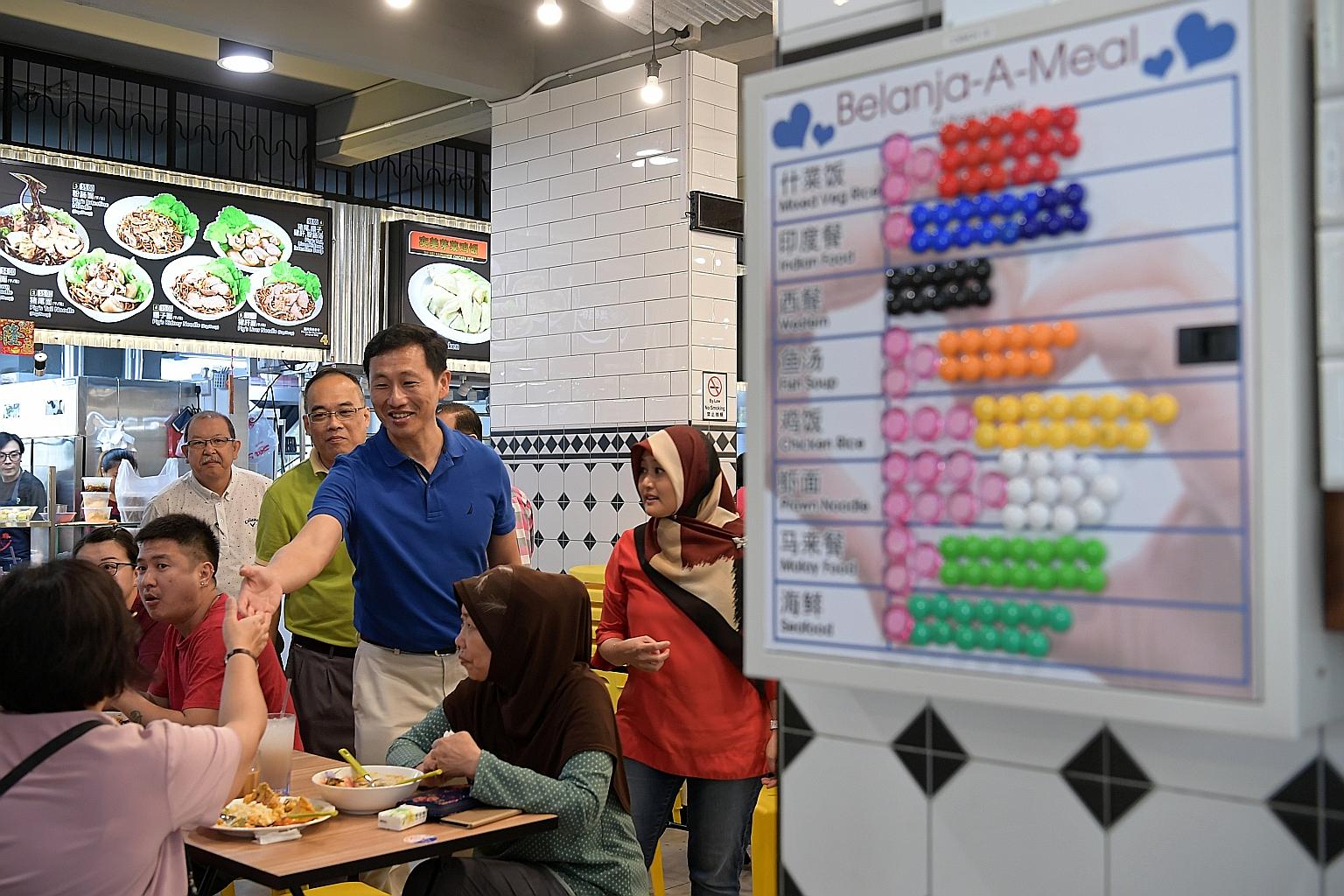 Minister for Education (Higher Education and Skills) Ong Ye Kung (in blue) with Jurong GRC MP Rahayu Mahzam (in red) at the De Tian Coffee House in Bukit Batok East, where the "Belanja-A-Meal" programme was recently launched. It allows diners to anon