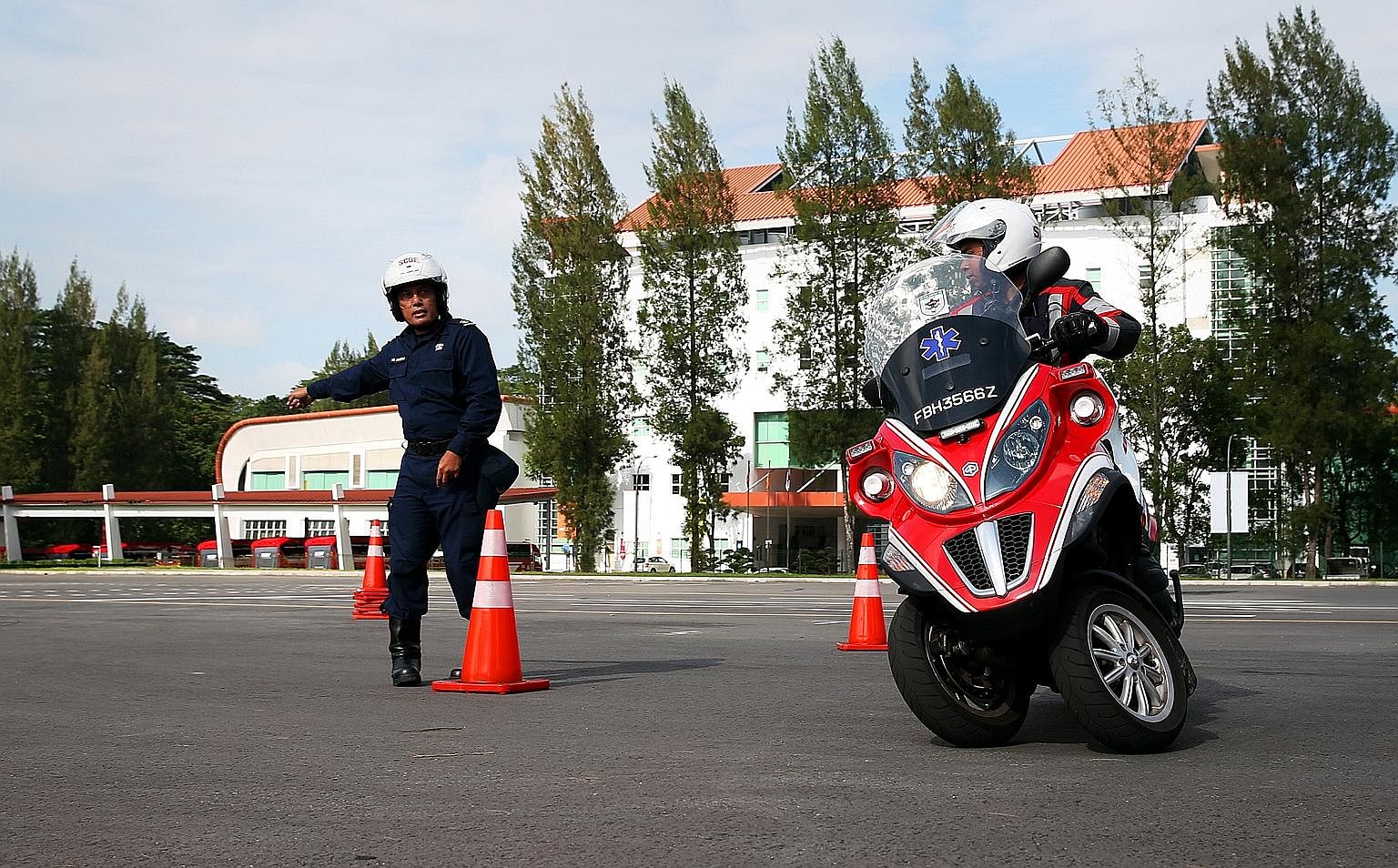 When a turnout occurs, firebiker Md Hilmi Md Fuad slides down a pole (left) to get to his three-wheeled scooter quickly. At the Civil Defence Academy in Jalan Bahar, firebikers like Staff Sergeant Hilmi are required to go through a riding course to b