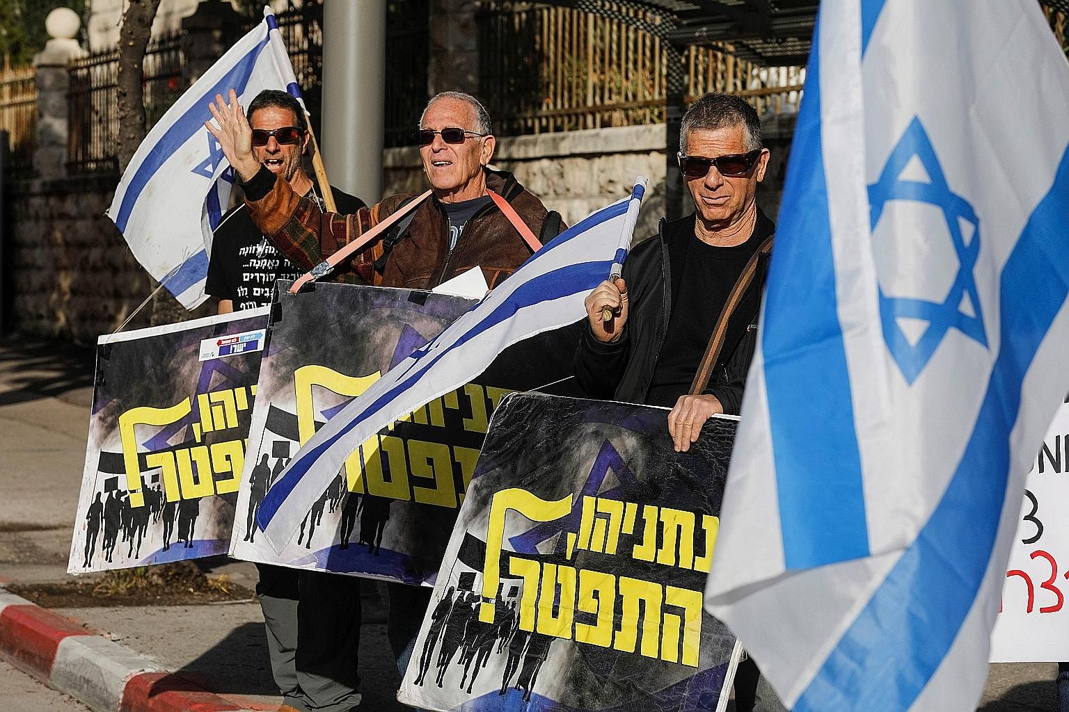 Protesters holding signs saying "Netanyahu resign" at a demonstration in front of Mr Benjamin Netanyahu's residence in Jerusalem on Wednesday.