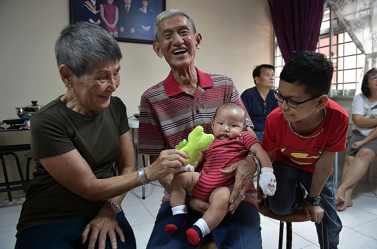 Mr Ng Ghim Tin, 82, and his wife Lim Lay Hin, 78, with their great grandson Ethan and grandson Caleb, 10. All 18 family members gathered for their reunion dinner in Pasir Ris last night in a Chinese New Year tradition. This year, the Ngs celebrated t
