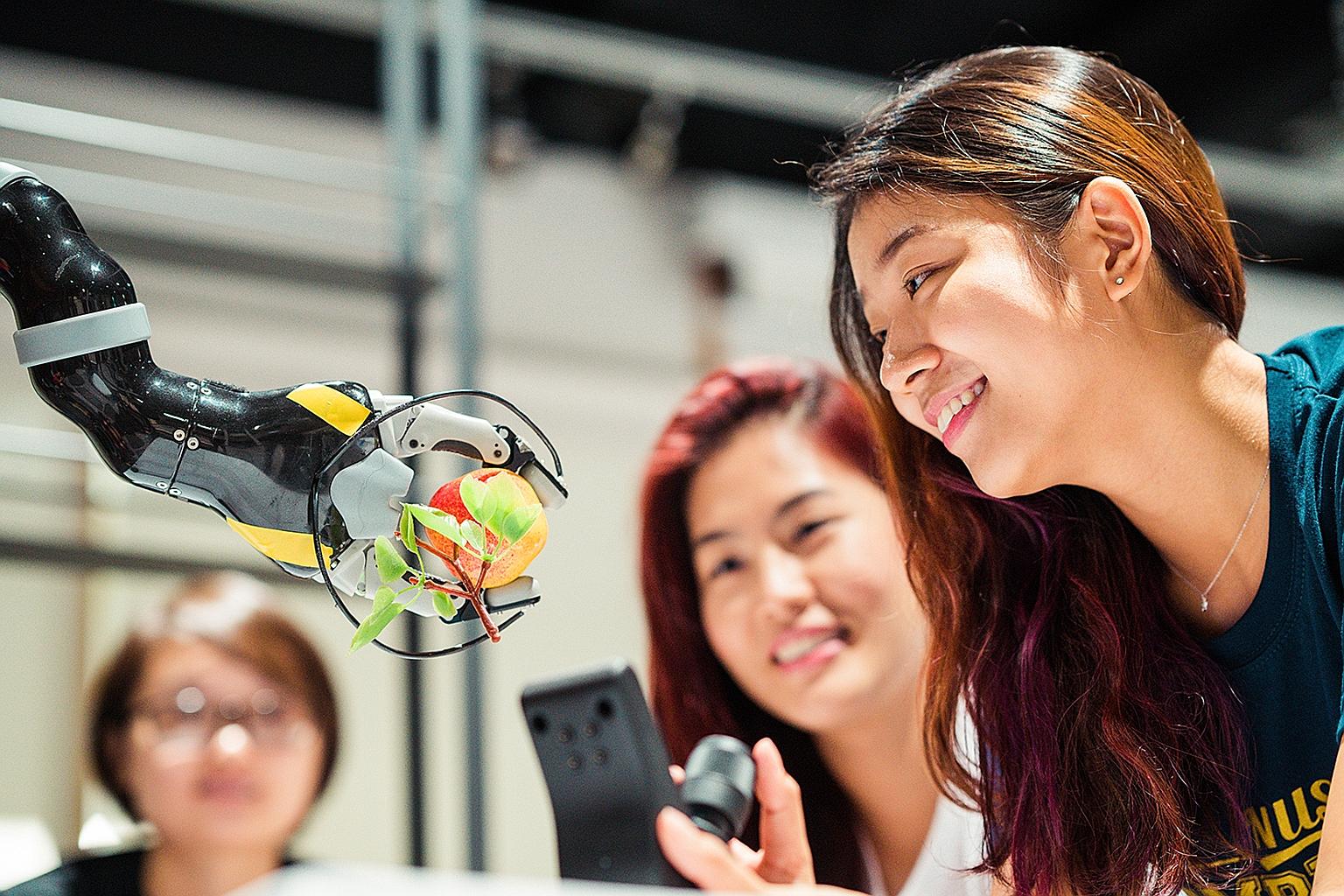 Computing students at NUS learning how technologies can improve daily living. The university will take in about 900 freshmen across six computing courses for the new academic year, up from the current 732.