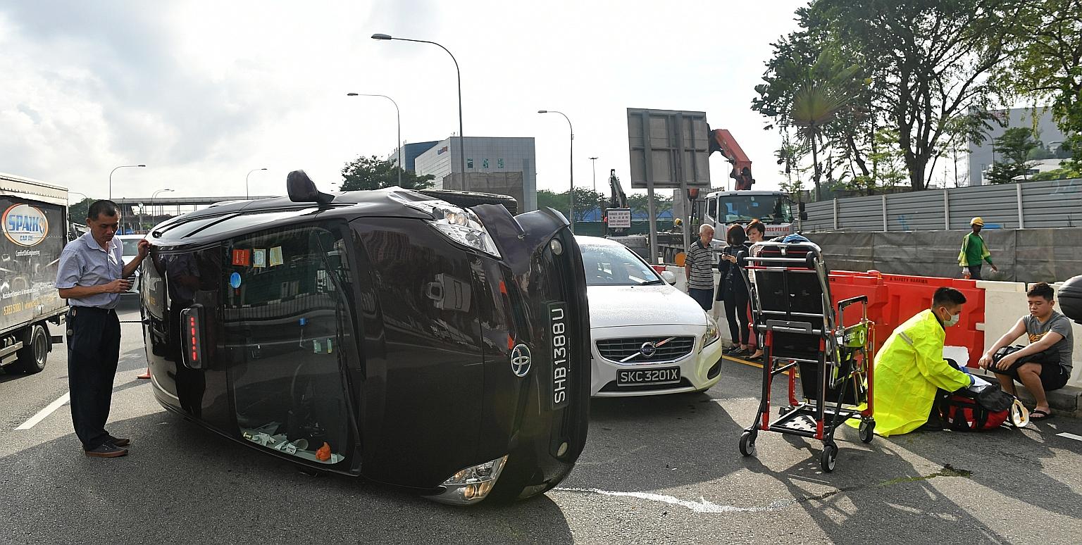 A taxi driver standing by his vehicle after an accident in Braddell Road in January last year. Taxis, which make up a mere 2.4 per cent of the total vehicle population here, accounted for 13 per cent of accidents reported last year, statistics gather