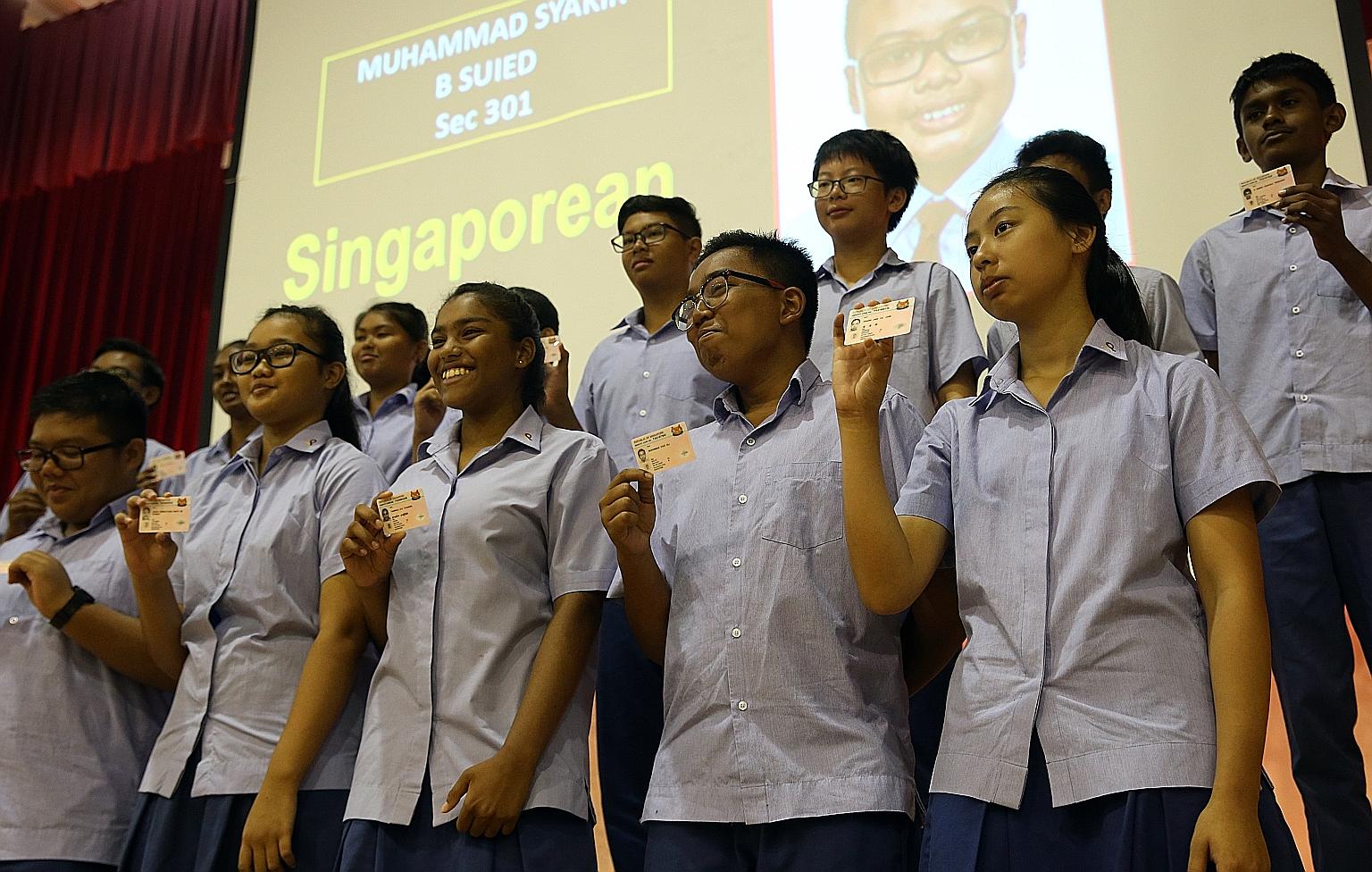 More than 70 Secondary 3 students from Ping Yi Secondary School receiving their NRICs at a presentation ceremony at their school yesterday. Before the ceremony, the students took part in a reflection session on what it means to be Singaporean.