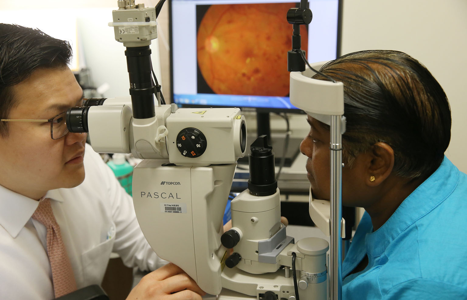 Dr Gavin Tan, a consultant ophthalmologist with SNEC's surgical retina department, demonstrating how laser treatment can be used for a patient's diabetic eye disease.