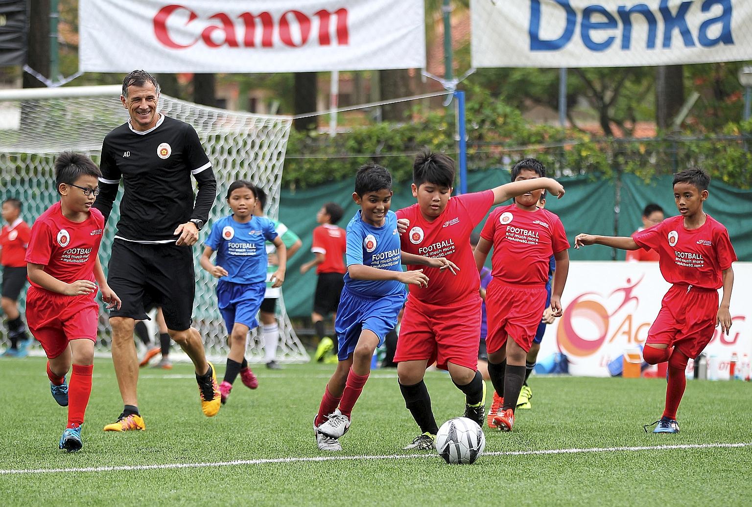 Children at the ActiveSG Football Academy with former national player Aleksandar Duric. More academies in different sports are in the pipeline.