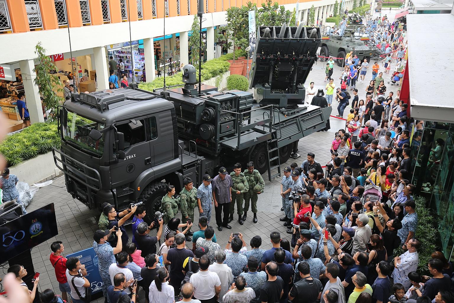 Minister of Defence Ng Eng Hen with RSAF airmen at the celebrations at the HDB Hub in Toa Payoh yesterday. The event showcased the force's capabilities through static displays of aircraft and weapon systems.