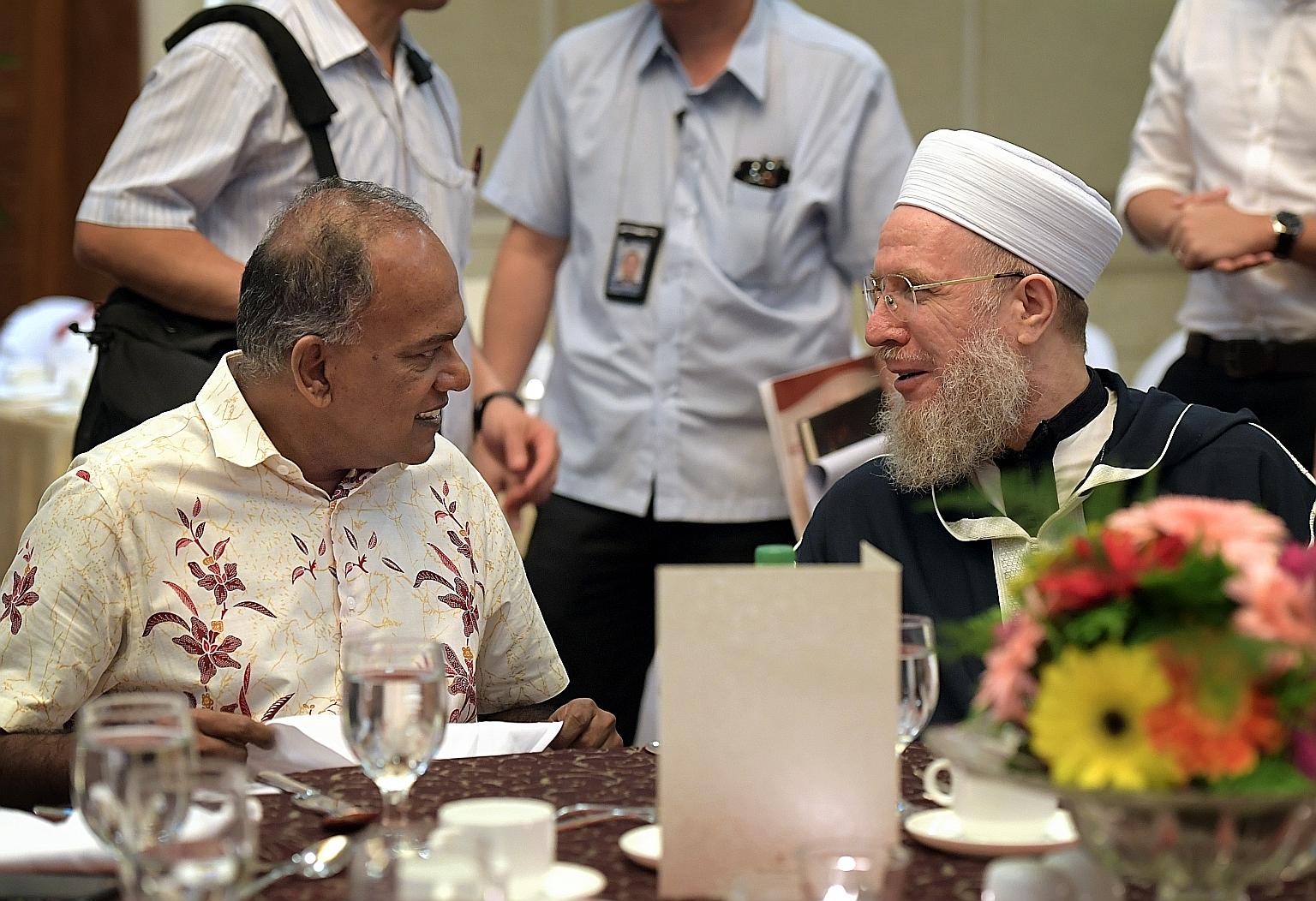 Home Affairs Minister K. Shanmugam speaking with Syrian Islamic scholar Shaykh Sayyid Muhammad Al-Yaqoubi at the Religious Rehabilitation Group's 14th Annual Retreat yesterday.