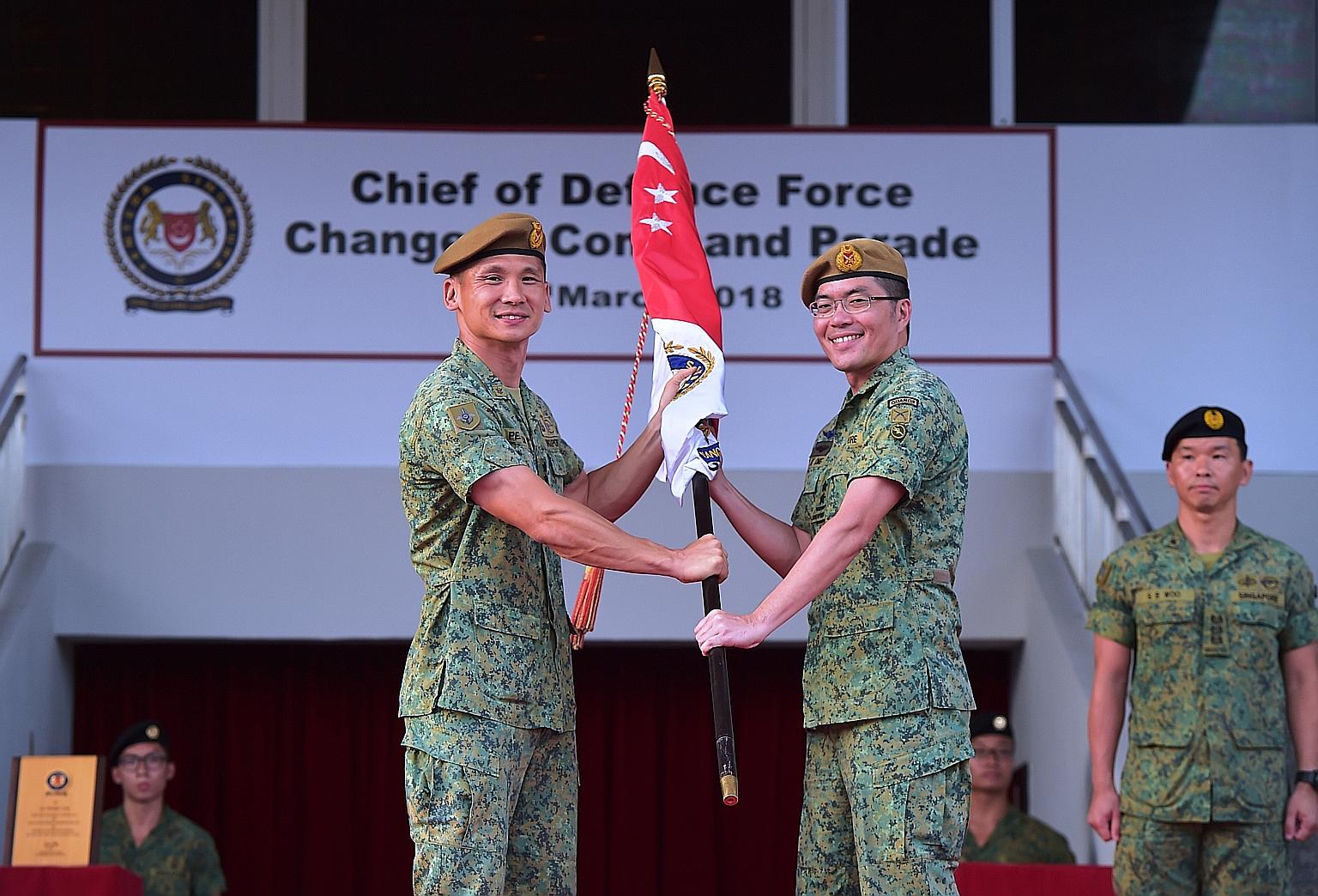 Former army chief Major-General Melvyn Ong Su Kiat yesterday (centre, right) took over as Chief of Defence Force, at a Change of Command Parade held at the Safti Military Institute. Maj-Gen Ong, 43, received the command symbol from the outgoing Chief