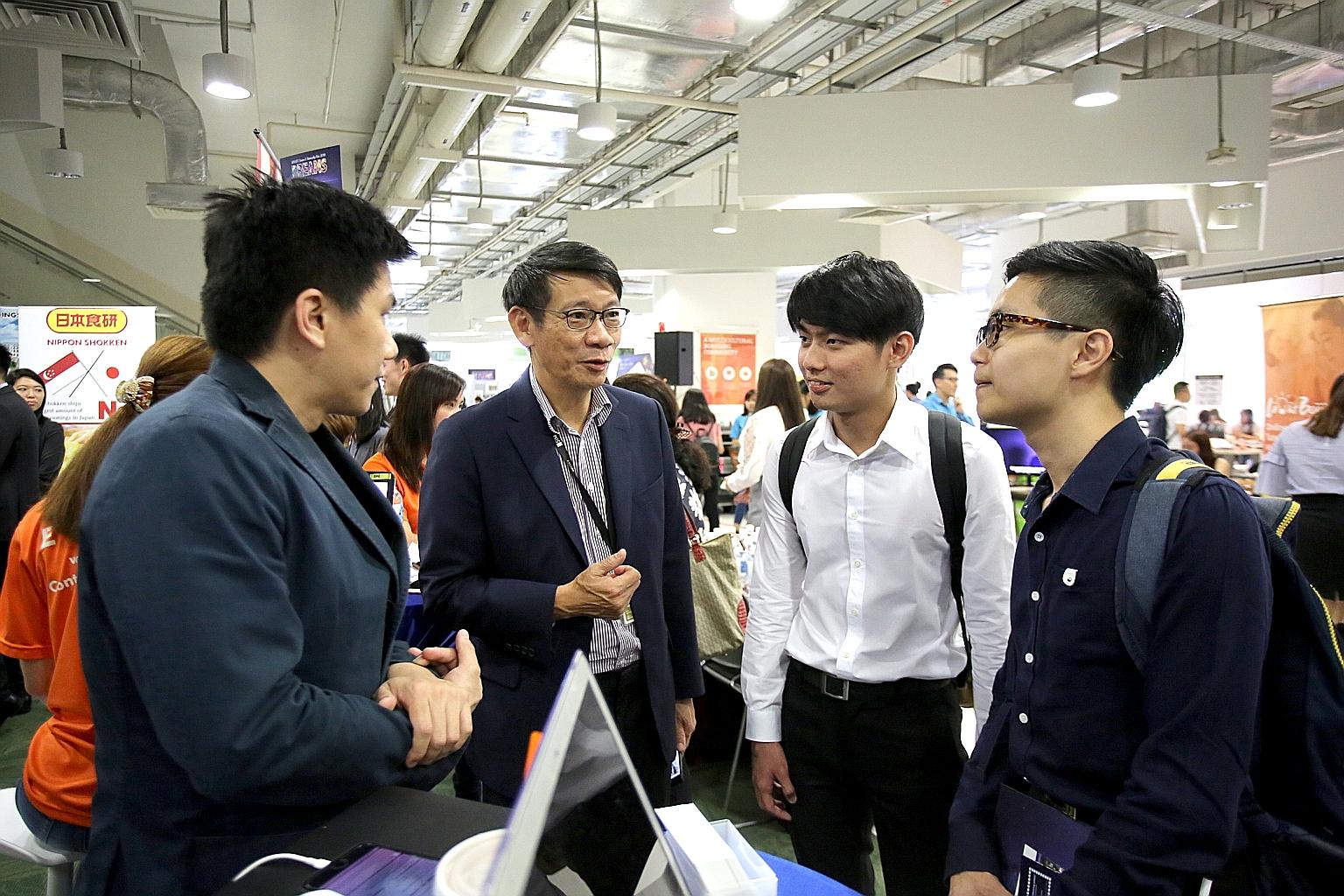 (From left) SIM alumnus Jasper Ong and SIM Holdings chief executive officer Lee Kwok Cheong with SIM students Tan Wei Liang, 24, and Jeremiah Toh Song Tat, 23, at the school's career fair last month that saw a record 126 companies taking part, includ