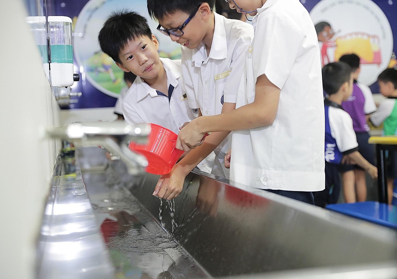 Kuo Chuan Presbyterian Primary School pupils coping without tap water, as part of a water-rationing exercise.