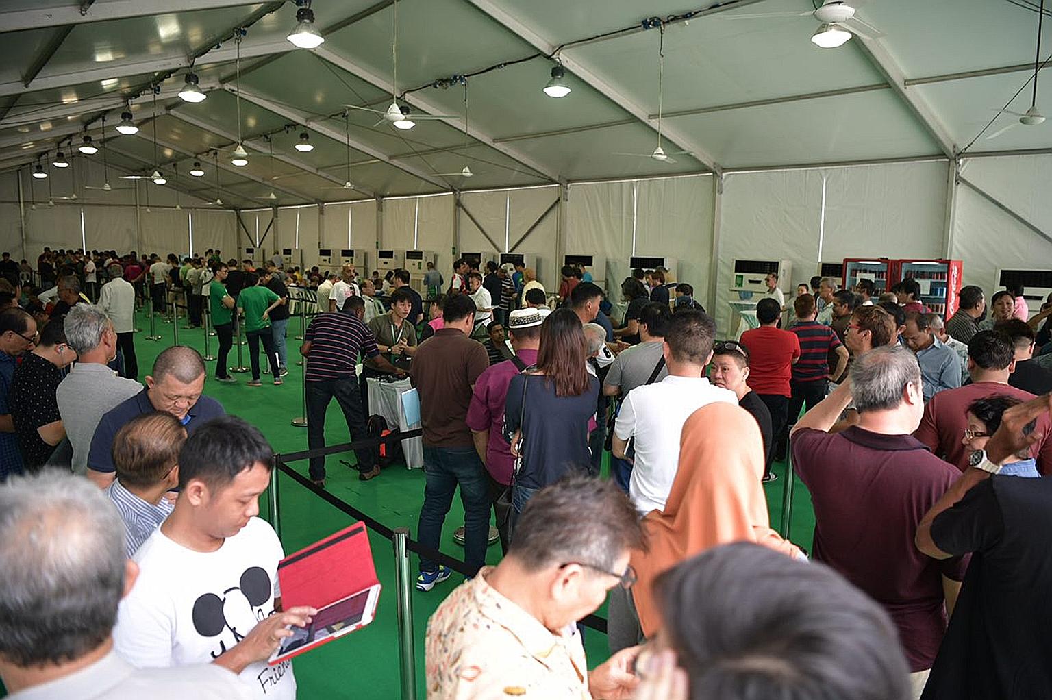 Former Uber drivers queueing on Monday to register with Grab at Midview City in Sin Ming, where Grab's driver centre is located.