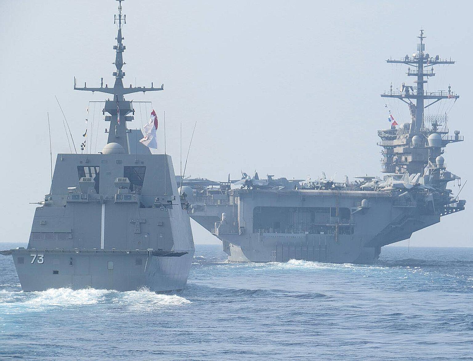 The RSS Supreme Formidable-class frigate (left) sailing in formation with the USS Theodore Roosevelt aircraft carrier. They are taking part in a passage exercise between the Singapore and US navies.