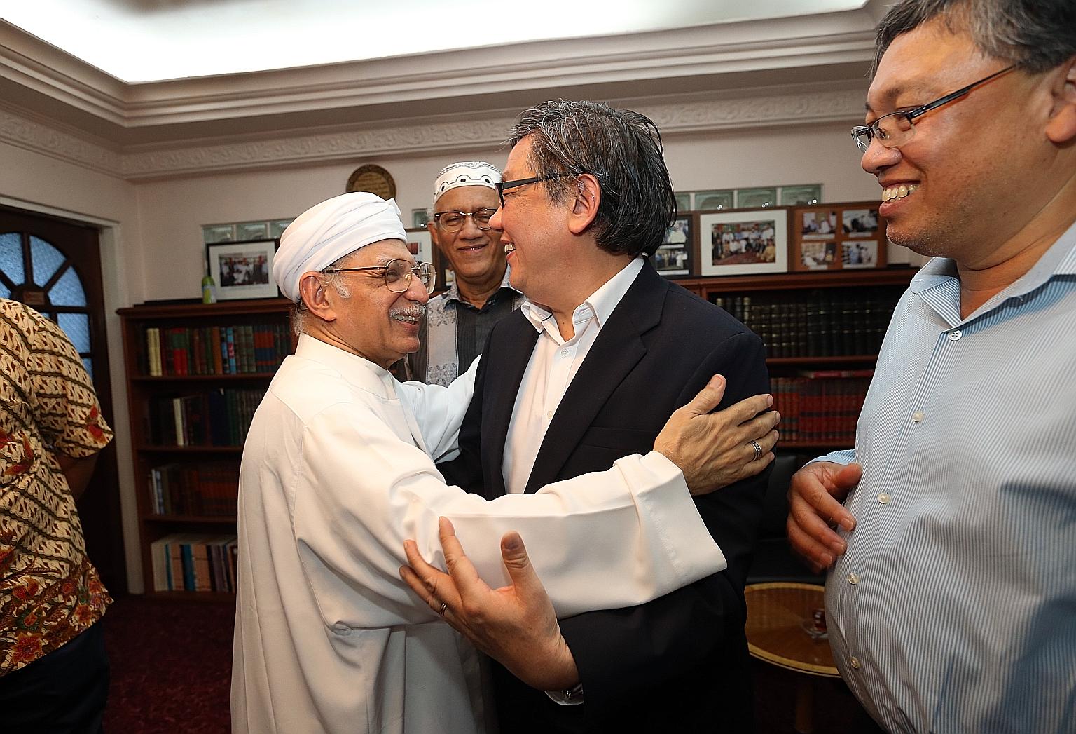 Ba'alwie Mosque's Imam Habib Hassan Al-Attas embracing Pastor Yang Tuck Yoong. Other guests at the meeting included Mr Mohamed Abdullah Alhabshee (centre), the husband of President Halimah Yacob, and Malaysian High Commissioner to Singapore Zulkifli 
