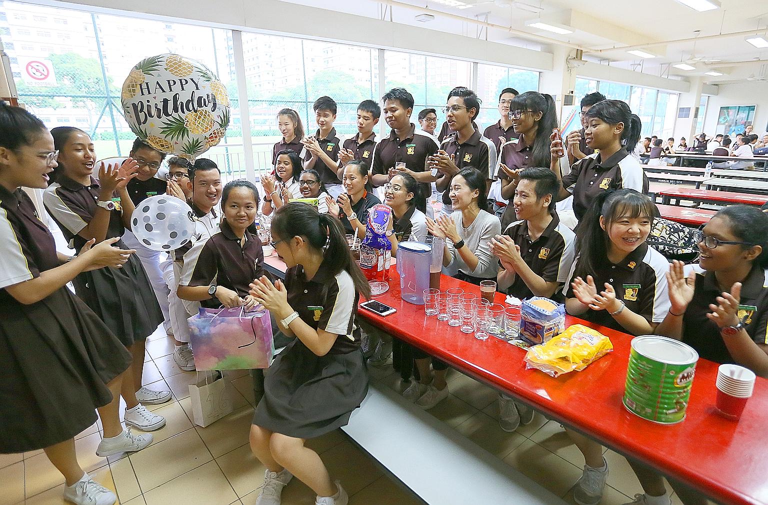 Dunman Secondary form teacher Wong Li Qin and her Secondary 4 students having a surprise birthday celebration for Nur Anisa Dzulraini (holding bag). Having breakfast together in the canteen every Friday has helped to forge closer ties between the stu