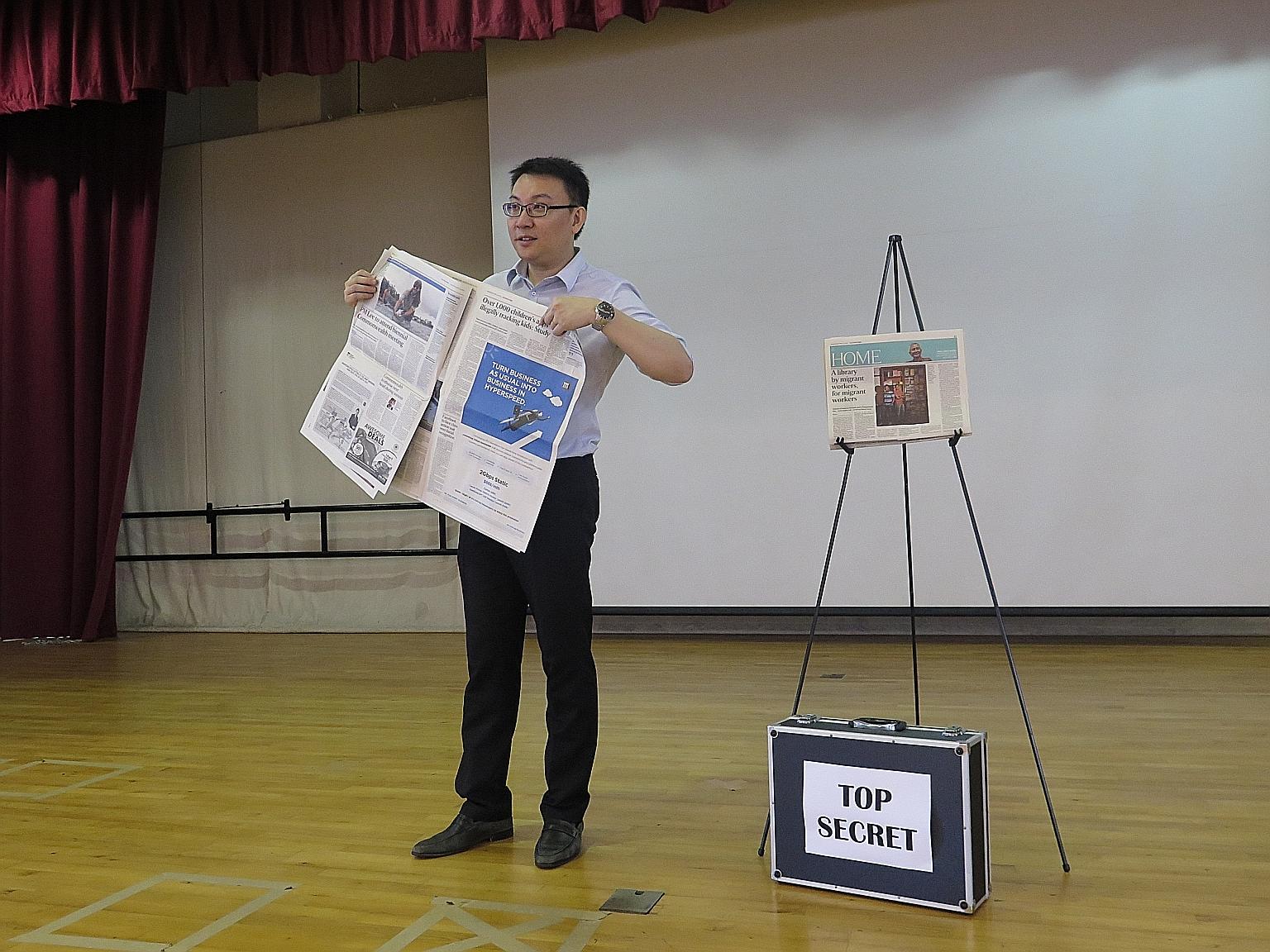 Mr Edwin Wan holding up a copy of The Straits Times as he unveils his predictions during a session in Yio Chu Kang Primary School last Wednesday. The head of the English language department hopes to motivate pupils to want to find out more about thin