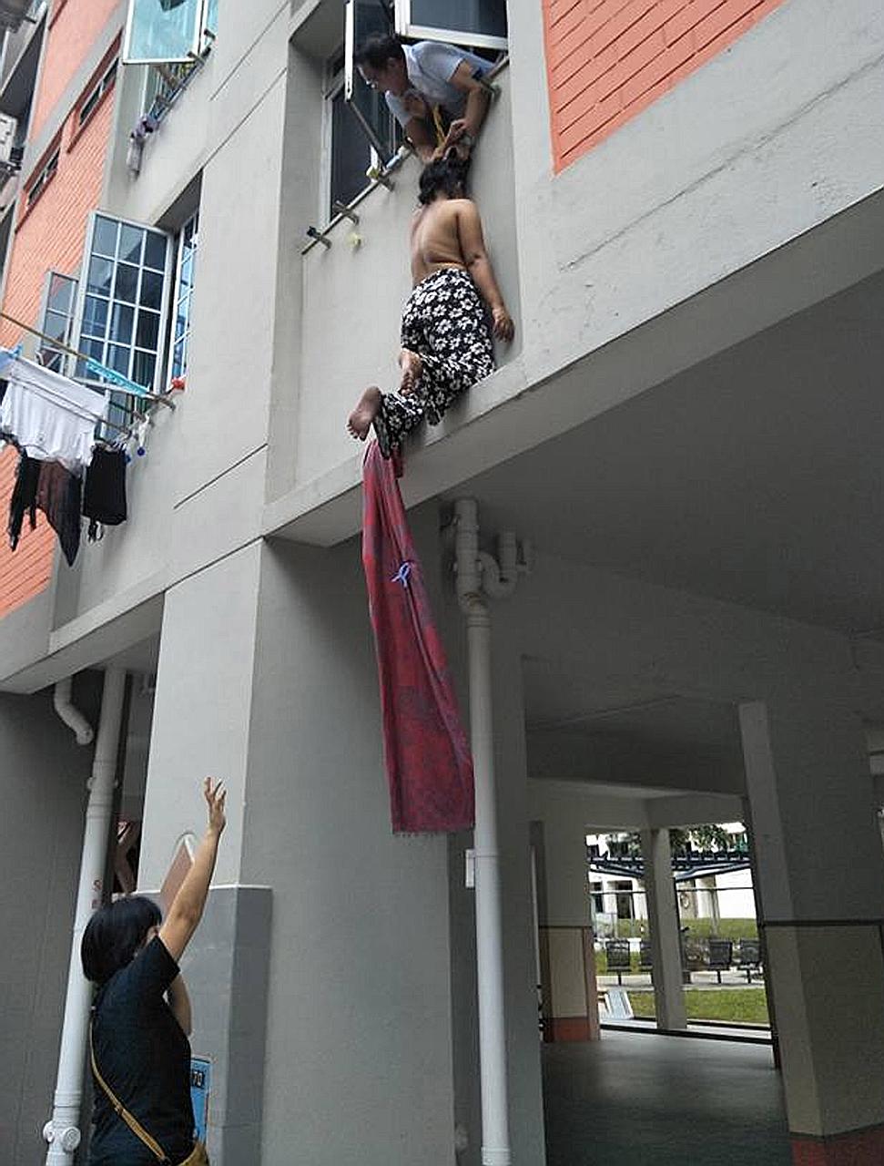 In a video that has been circulating on Facebook, the woman is seen being held by Mr Azman Jalil. In another video clip, she is seen lying at the foot of the block.
