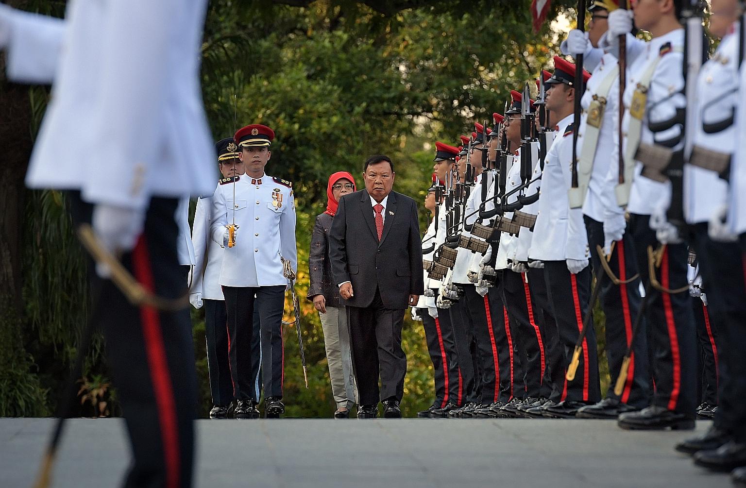 Laos President Bounnhang Vorachith inspecting the guard of honour with President Halimah Yacob at the Istana yesterday. As part of the state visit, President Halimah held a welcome ceremony and state banquet at the Istana in President Bounnhang's hon