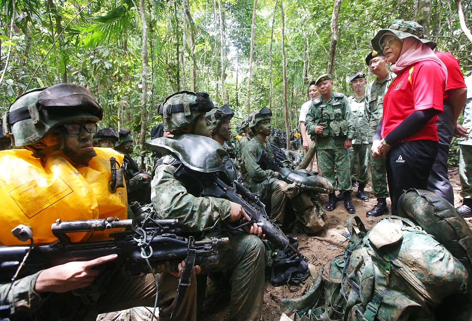 President Halimah Yacob, accompanied by Chief of Army Goh Si Hou (on her right), speaking to SAF officer cadets during their training in Temburong in Brunei yesterday. When she visited the Defence Academy of the Royal Brunei Armed Forces on Saturday,