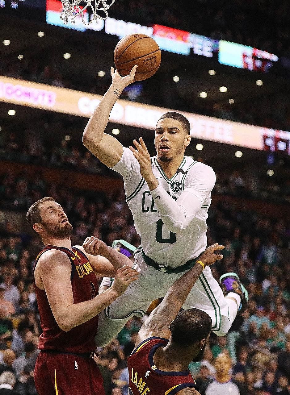 Boston's Jayson Tatum is airborne as he drives past Kevin Love and LeBron James in the 108-83 victory over Cleveland in Game 1 of the Eastern Conference Finals.