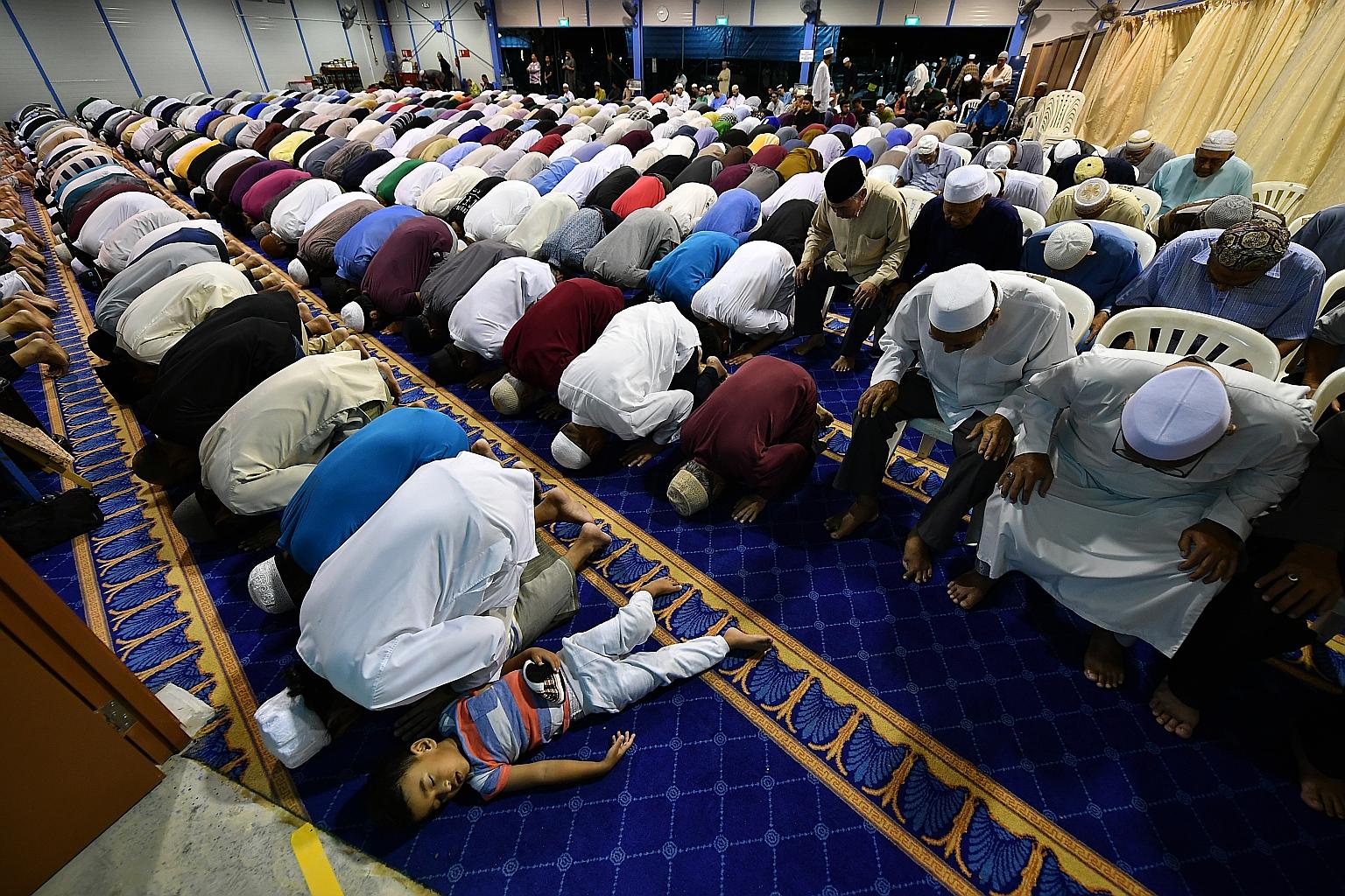Muslims performing special evening prayers yesterday, the first night of the holy fasting month of Ramadan, at the temporary site of Masjid Darul Ghufran in Tampines. Muslims in Singapore will begin fasting today and celebrate Hari Raya Puasa on June
