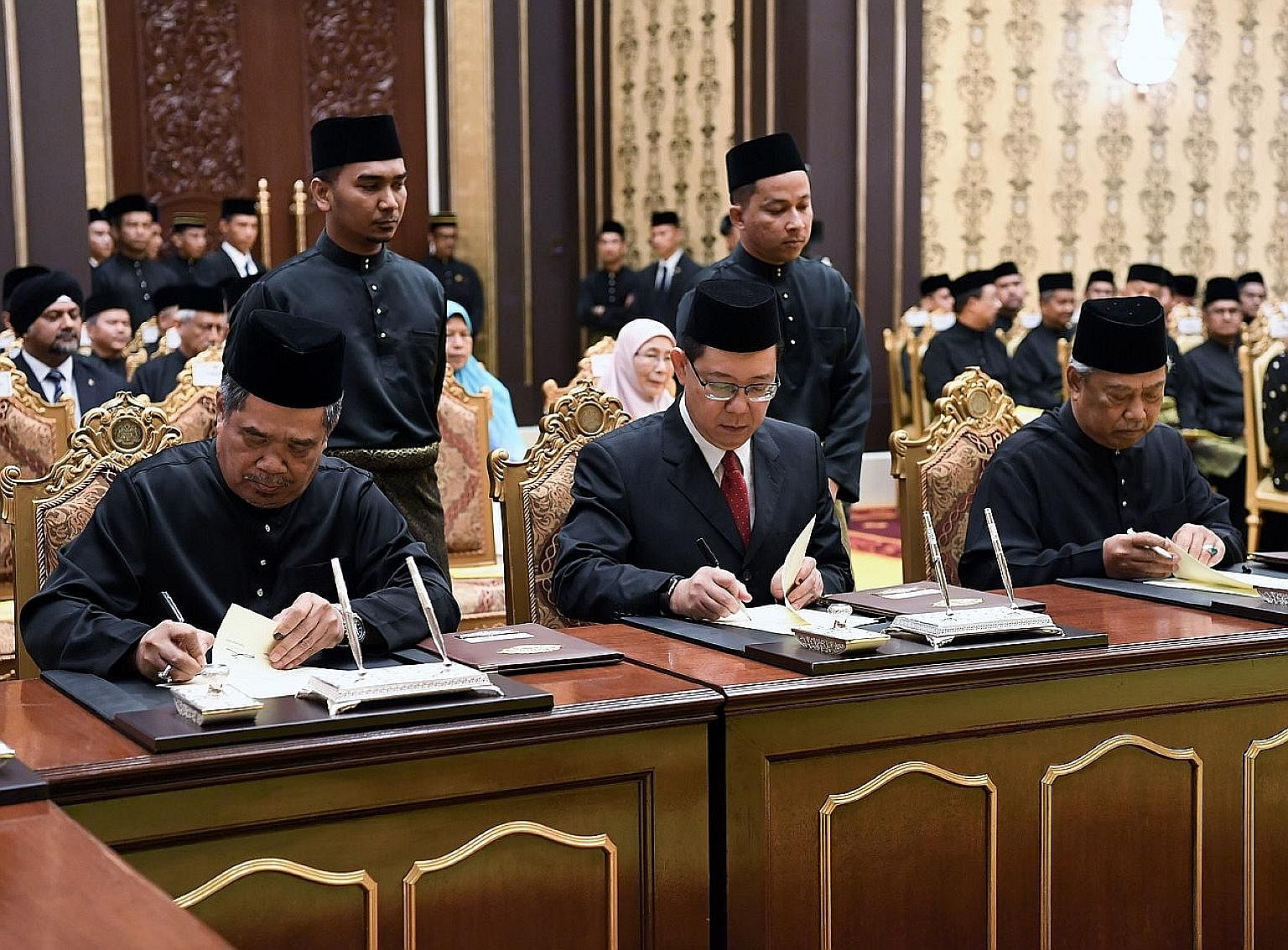 From left: Defence Minister Mohamad Sabu, Finance Minister Lim Guan Eng and Home Minister Muhyiddin Yassin signing their appointment letters at the Istana Negara in Kuala Lumpur yesterday. They were among 13 members of Tun Dr Mahathir Mohamad's core 