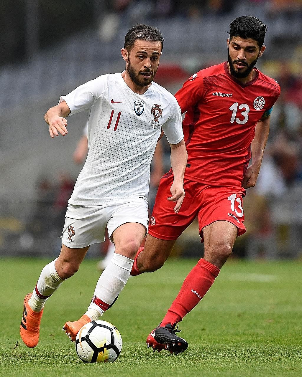 Portugal forward Bernardo Silva (left) being challenged by Tunisia midfielder Ferjani Sassi in their friendly match on Monday.