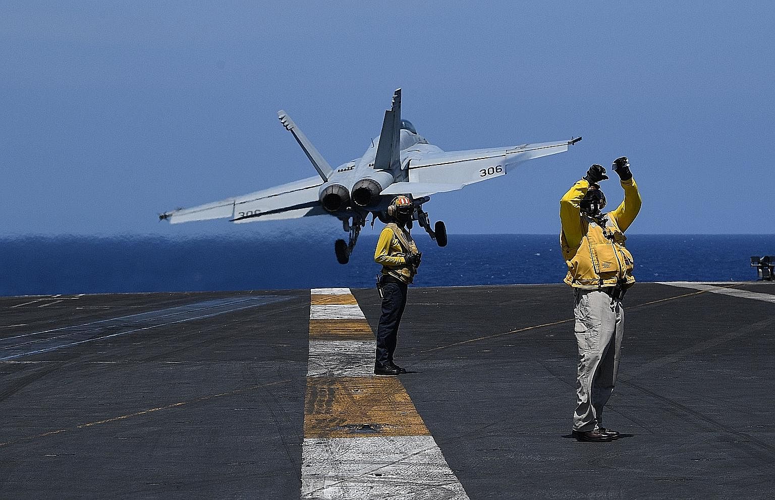 Sailors on flight deck duty as an FA-18 hornet fighter jet took off during routine training aboard US aircraft carrier Theodore Roosevelt in the South China Sea in April. As defence officials gather to discuss some of the Indo-Pacific's most pressing