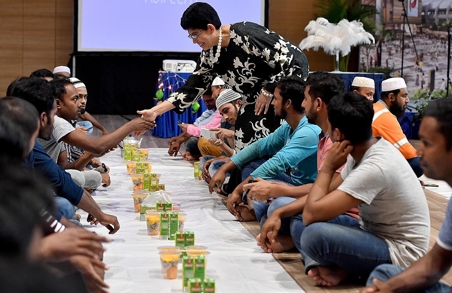 MP for Marine Parade GRC Fatimah Lateef shaking hands with a migrant worker during the Ramadan break fast session for about 240 migrant workers at Wisma Geylang Serai yesterday.