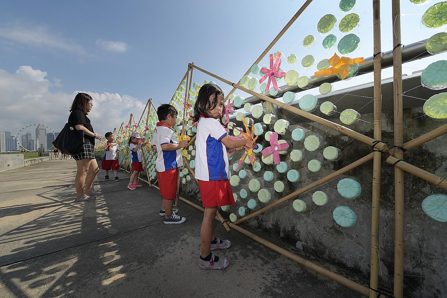 Pupils from PCF Sparkletots @ Zhenghua putting the finishing touches to a 120m caterpillar made of discarded plastic bottles at Marina Barrage. The art installation, which aims to raise awareness about plastic pollution, will be on display for a mont