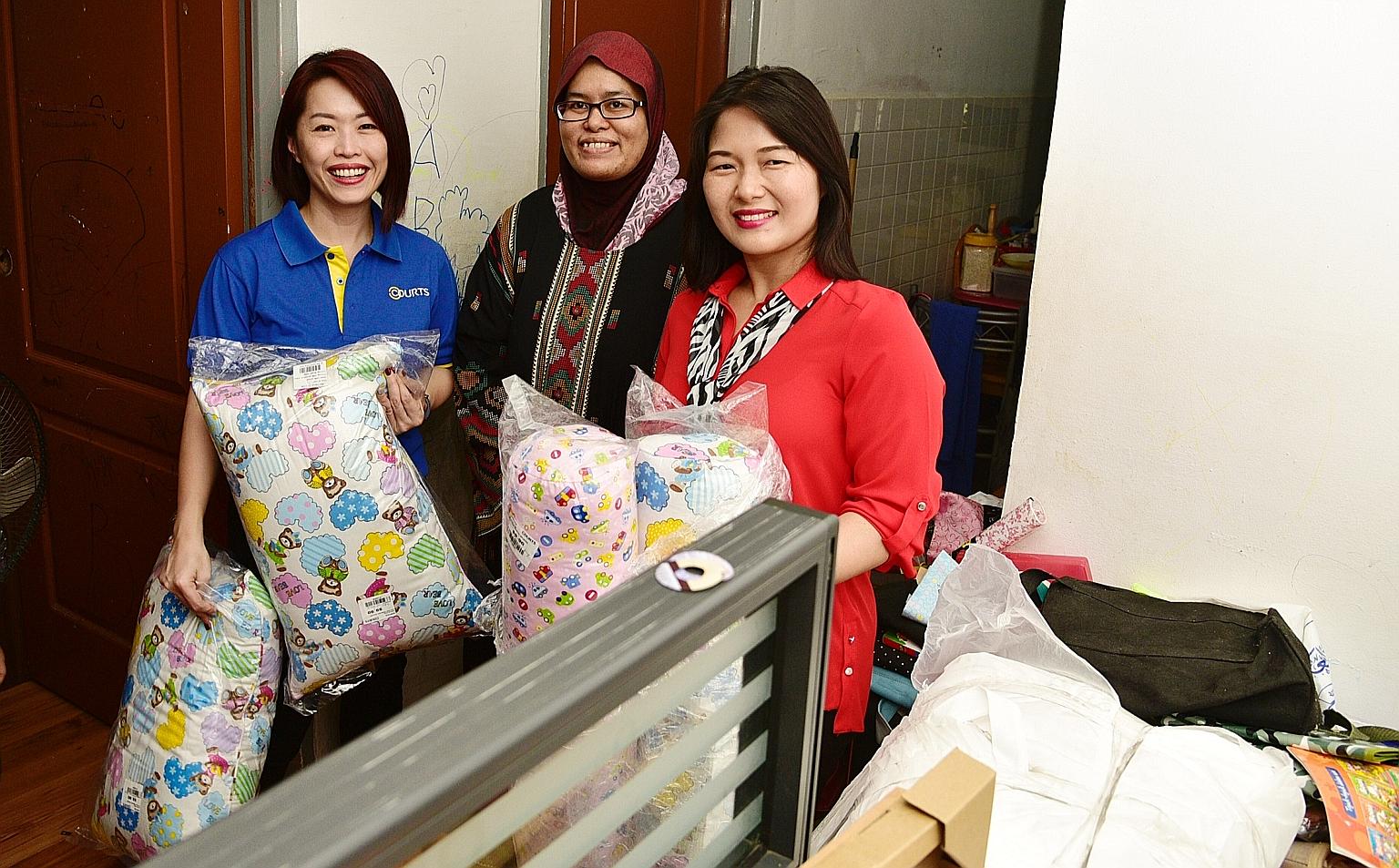 Madam Siti Norbayah (centre), like the other 21 low-income Muslim families in Serangoon and Ang Mo Kio, received furniture and appliances from Courts. Madam Siti is seen here with Courts Singapore marketing director Joanna Ho (left) and adviser to Al