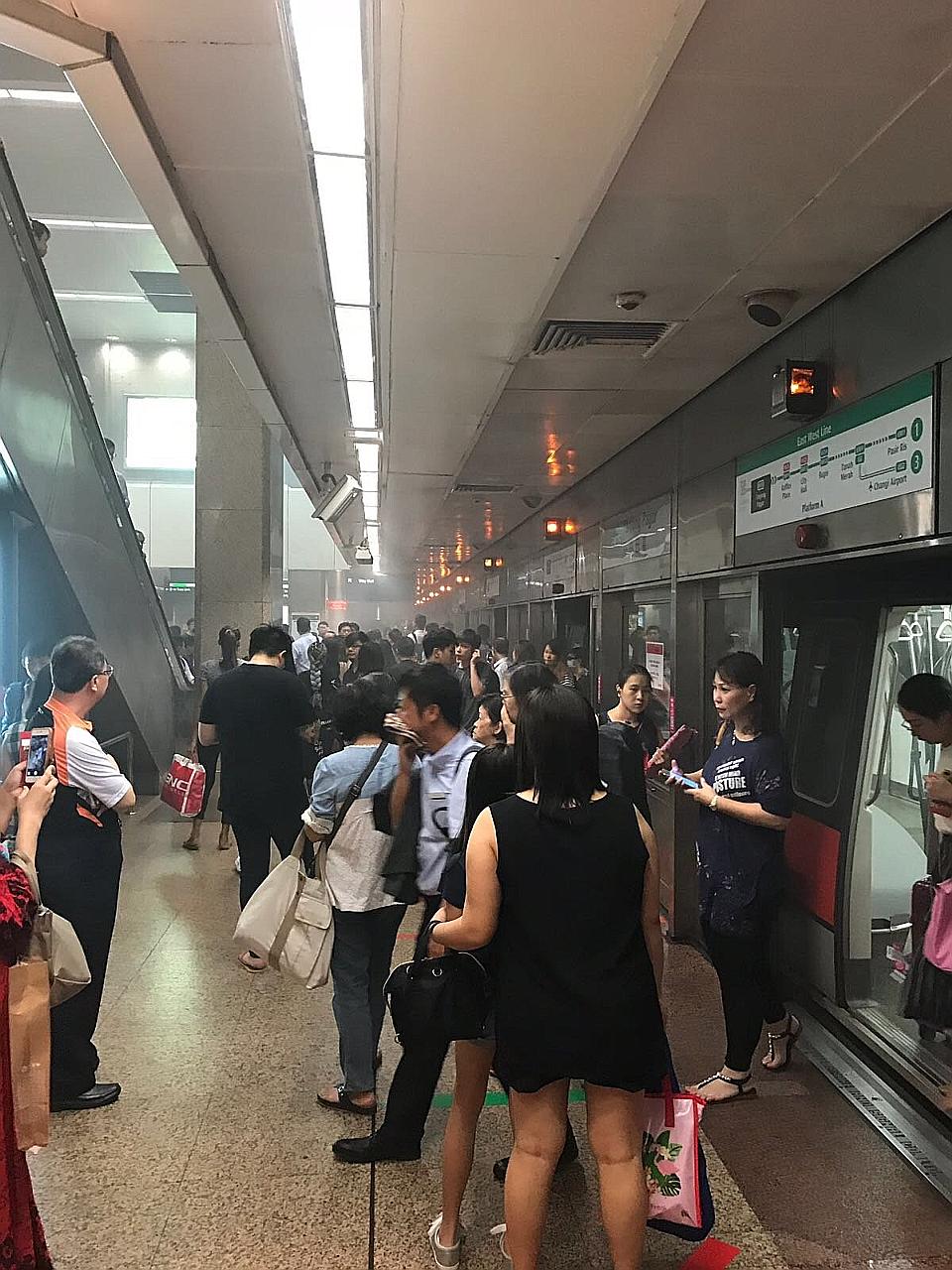 Commuters on the smoky platform at Tanjong Pagar MRT station yesterday morning. The train with the leaking air-conditioning compressor was withdrawn from service for checks, said SMRT.