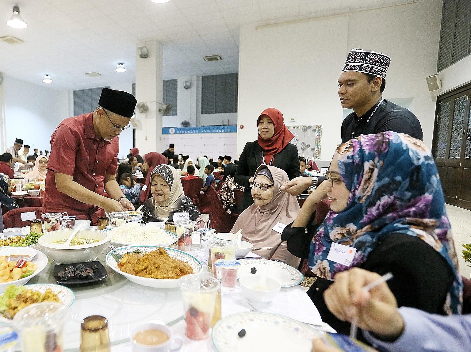 Minister-in-charge of Muslim Affairs Masagos Zulkifli serving food at Pertapis Senior Citizen Fellowship Home during the Ramadan Disbursement Ceremony yesterday. He said the move to revise eligibility criteria for zakat assistance comes amid inflatio