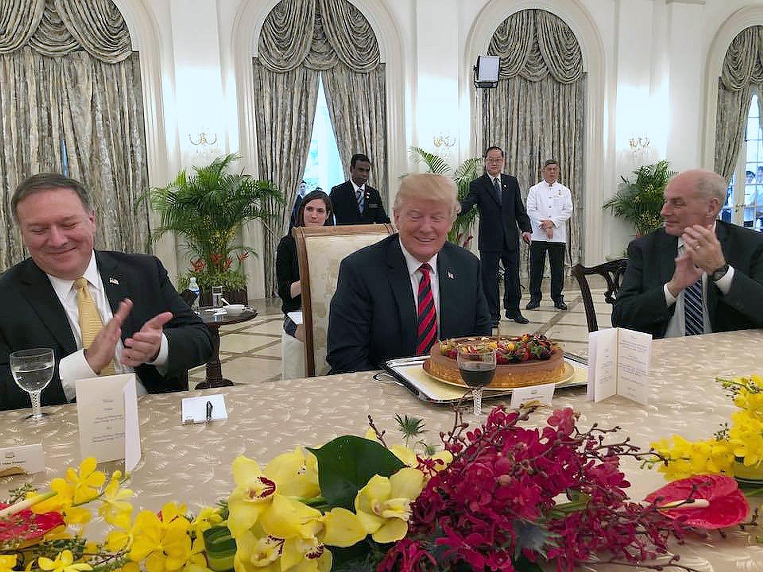 US President Donald Trump, who turns 72 on Thursday, celebrating his birthday early with Secretary of State Mike Pompeo (left) and Chief of Staff John Kelly yesterday. He was greeted with a birthday cake when he met Prime Minister Lee Hsien Loong for