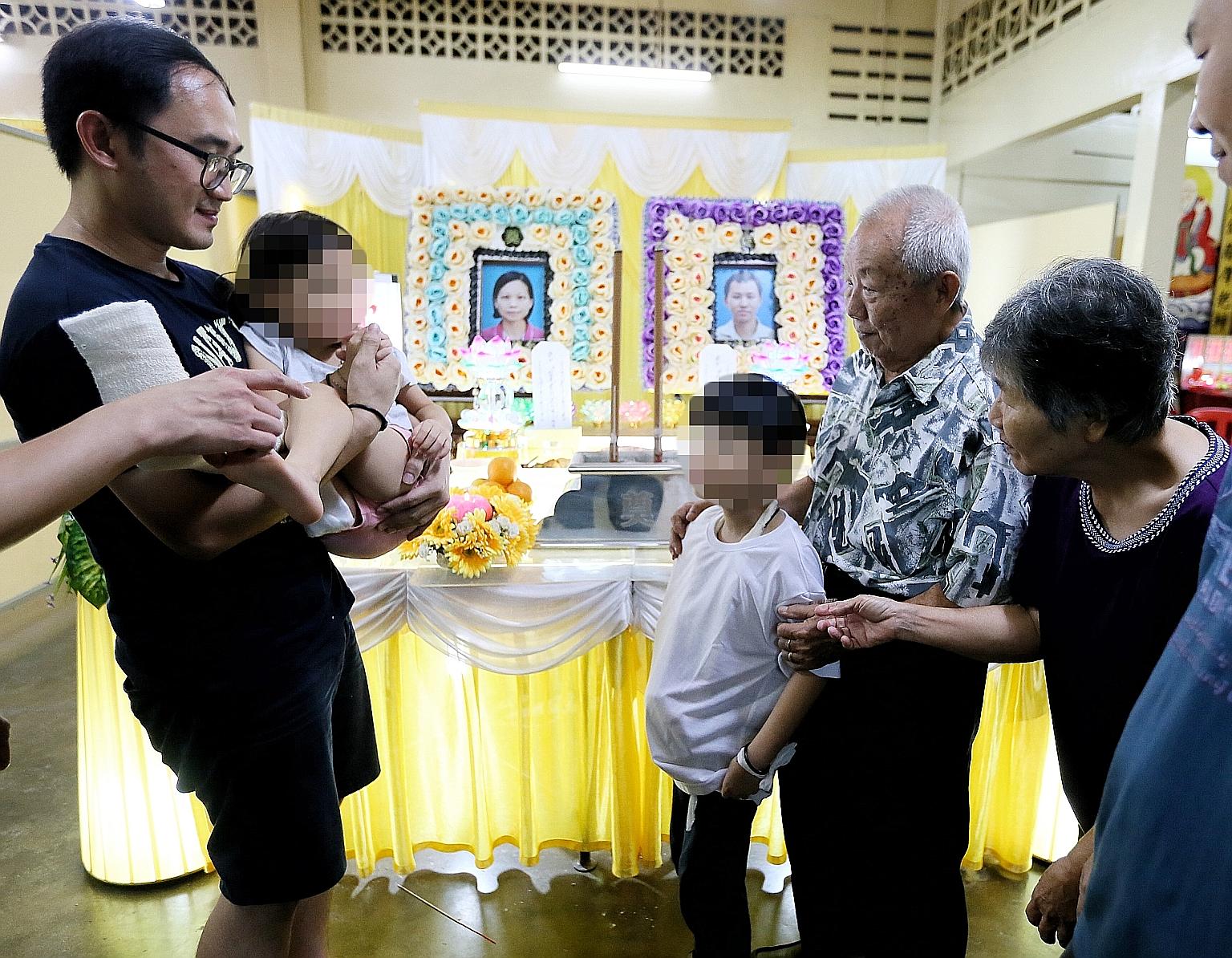 Chua Jun Xian, eight, and sister Xin Rou, five, the children of the couple who died in the crash, with their grandparents, Mr Chua Huat Chuan, 78, and Madam Sii Bee Tee, 69, and another relative at the wake in Seremban.