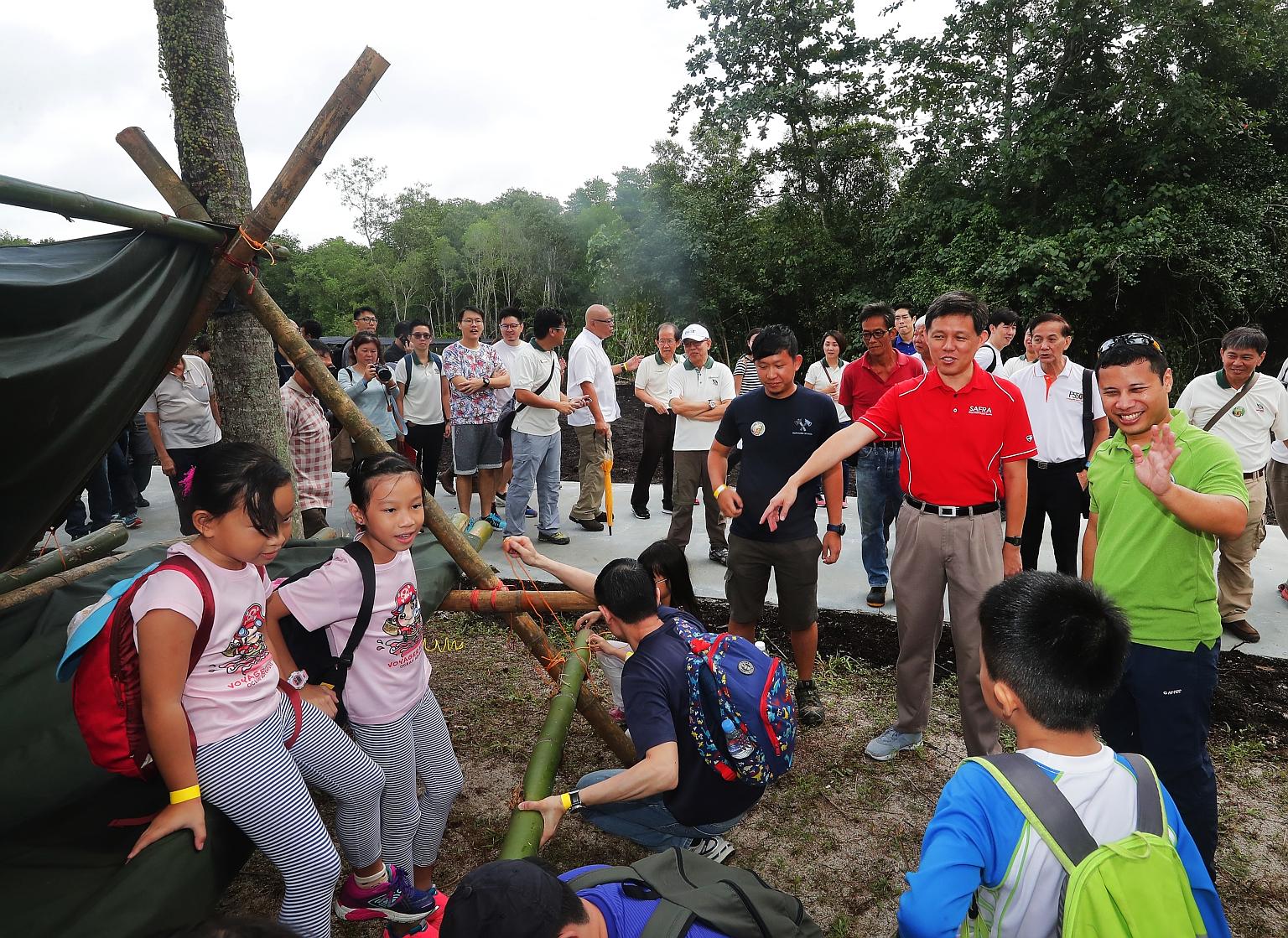 Minister for Social and Family Development Desmond Lee (in green shirt) and Trade and Industry Minister Chan Chun Sing touring the Ubin Living Lab, which supports field studies and environmental education on the island, yesterday.