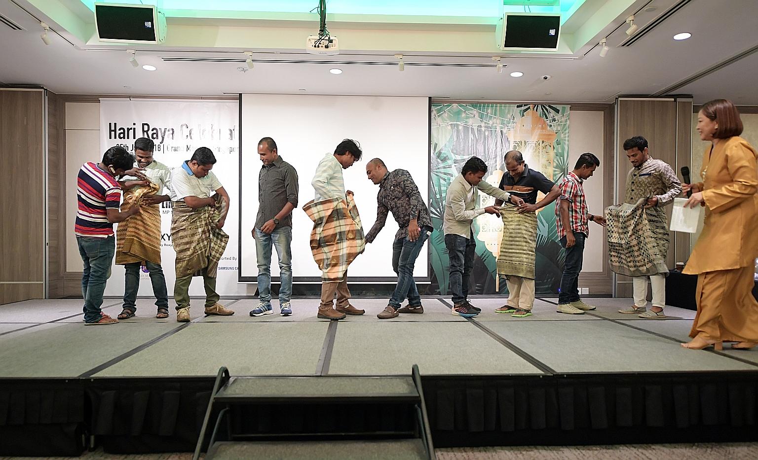 Foreign workers trying to knot a samping - a short version of a sarong - during a game at a dinner organised by Roxy Foundation and Samsung C&T Corporation last night. The dinner, held at Grand Mercure Singapore Roxy to mark Hari Raya Aidilfitri, was