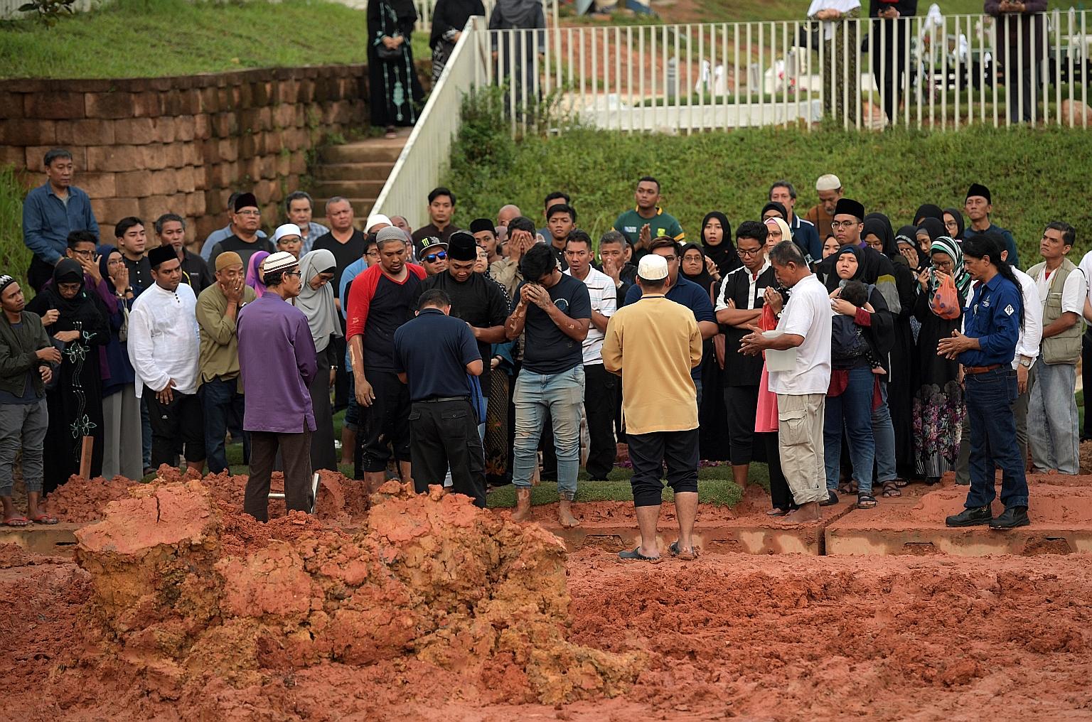 Madam Zarimah Mohamad's burial at the Choa Chu Kang Muslim Cemetery yesterday. Her eldest son said she had Stage 3 breast cancer about five years ago. She had surgery and chemotherapy, and had been feeling unwell since, but chose to continue working
