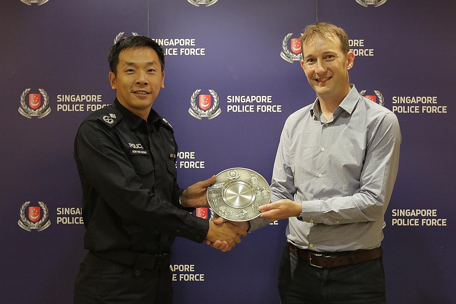 Assistant Commissioner of Police Koh Wei Keong, at the Public Transport Security Command, presenting the Public Spiritedness Award to Mr Keith Goldfinch, who was being honoured for helping the police to nab an upskirt video suspect in Newton MRT stat