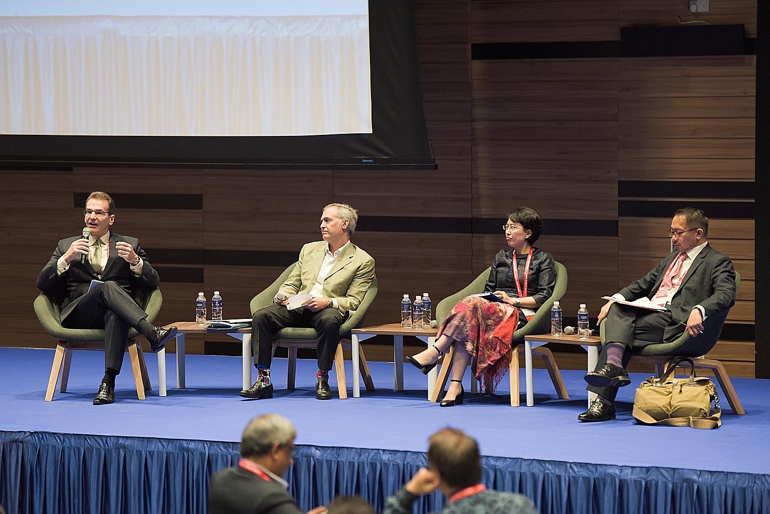(From left) Mr Stephen Olson, research fellow at the Hong Kong-based Hinrich Foundation, moderating yesterday's panel discussion with Mr Steven Okun, who sits on the board of the American Chamber of Commerce in Singapore, Ms Pan Xiaoming, research fe