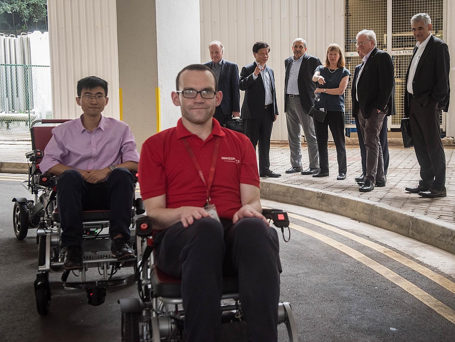 Members of the International Academic Advisory Panel observing a demonstration of Folo Fleet, a semi-autonomous smart mobility device convoy system, at NTU on Wednesday, as part of their three-day meeting. Key topics discussed were the value of a deg