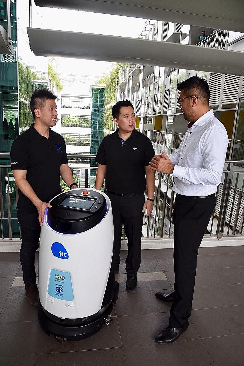 (From left) Gaussian Robotics director Aloysius Chong, JTC building management division director Jason Foo and WIS chief commercial officer Kelvin Lee with robot Scrub 50.