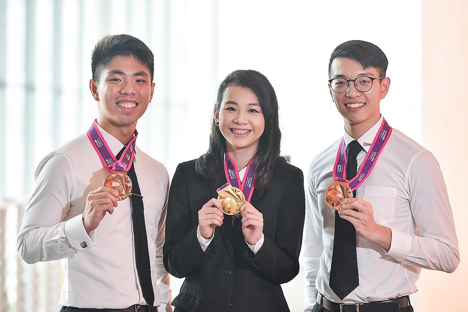 ITE College East student Shauna Tan with SIT students Lewis Tan (far left) and Toh Shu Han. Ms Tan is the first female to win in the Information Network Cabling category. Mr Tan and Mr Toh took the bronze medal in the Rapid Transit Systems category.