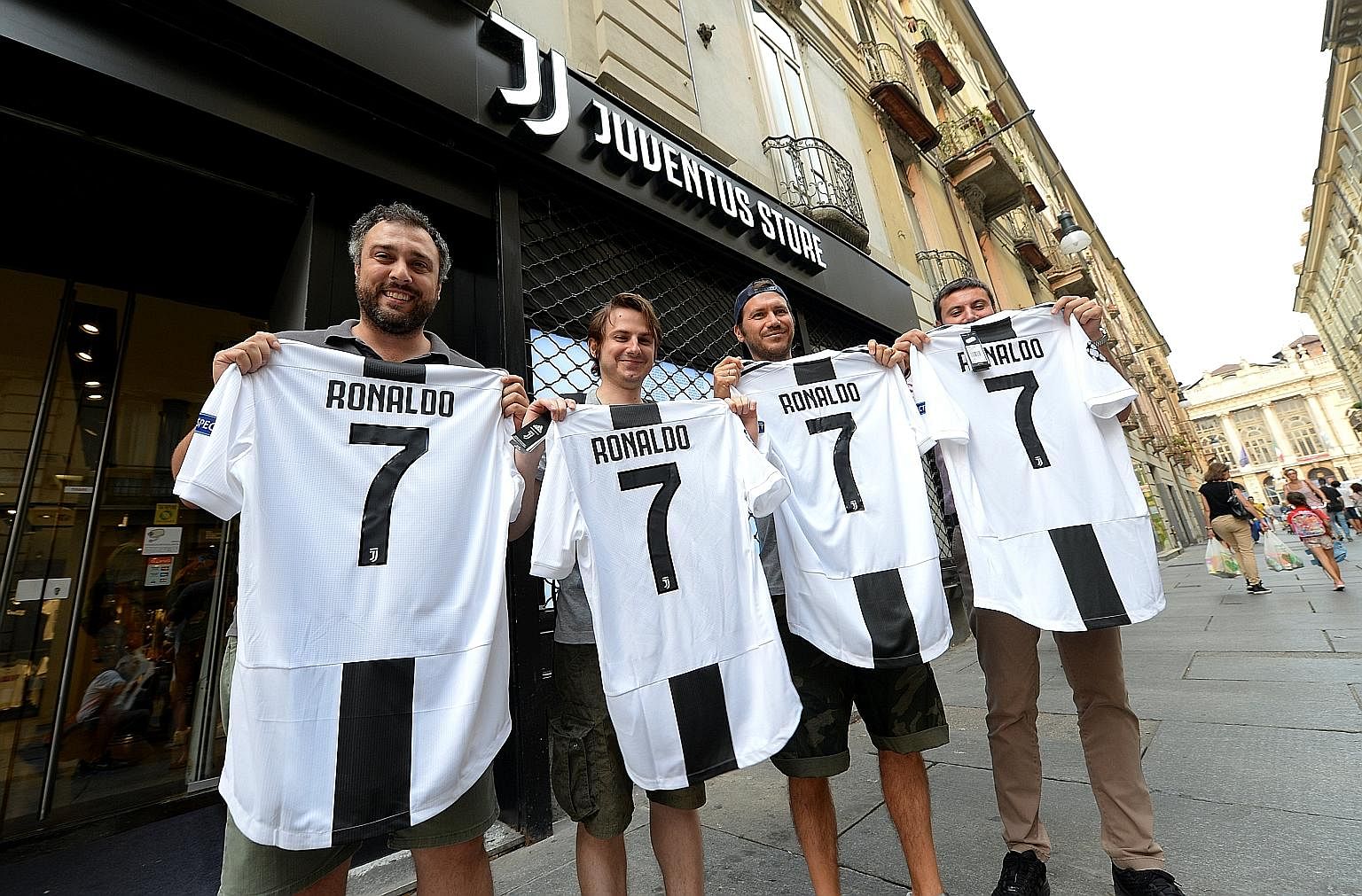 Juventus supporters posing with club shirts that have been adorned with the name and number of Cristiano Ronaldo after his €100 million (S$160 million) transfer from Real Madrid to the Italian champions on Tuesday.
