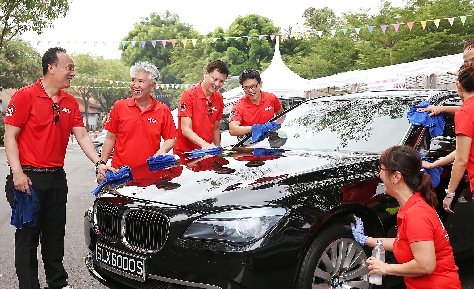 Great Eastern group chief executive Khor Hock Seng (second from left) was among 170 staff from the company who rolled up their sleeves to wash cars yesterday - all in the name of charity. They raised more than $60,000 for The Straits Times School Poc