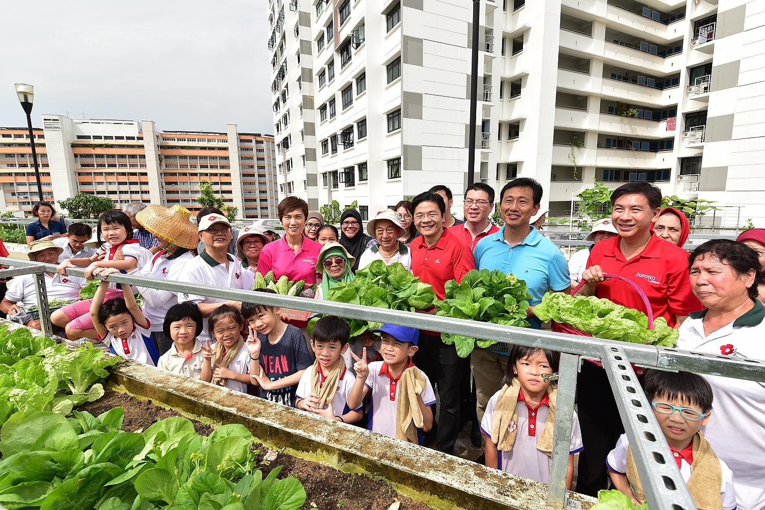 Education Minister Ong Ye Kung (third from right), National Development Minister Lawrence Wong (fourth from right) and Manpower Minister Josephine Teo (in pink) with Jurong GRC MP Ang Wei Neng (second from right), residents and PCF kindergarten pupil