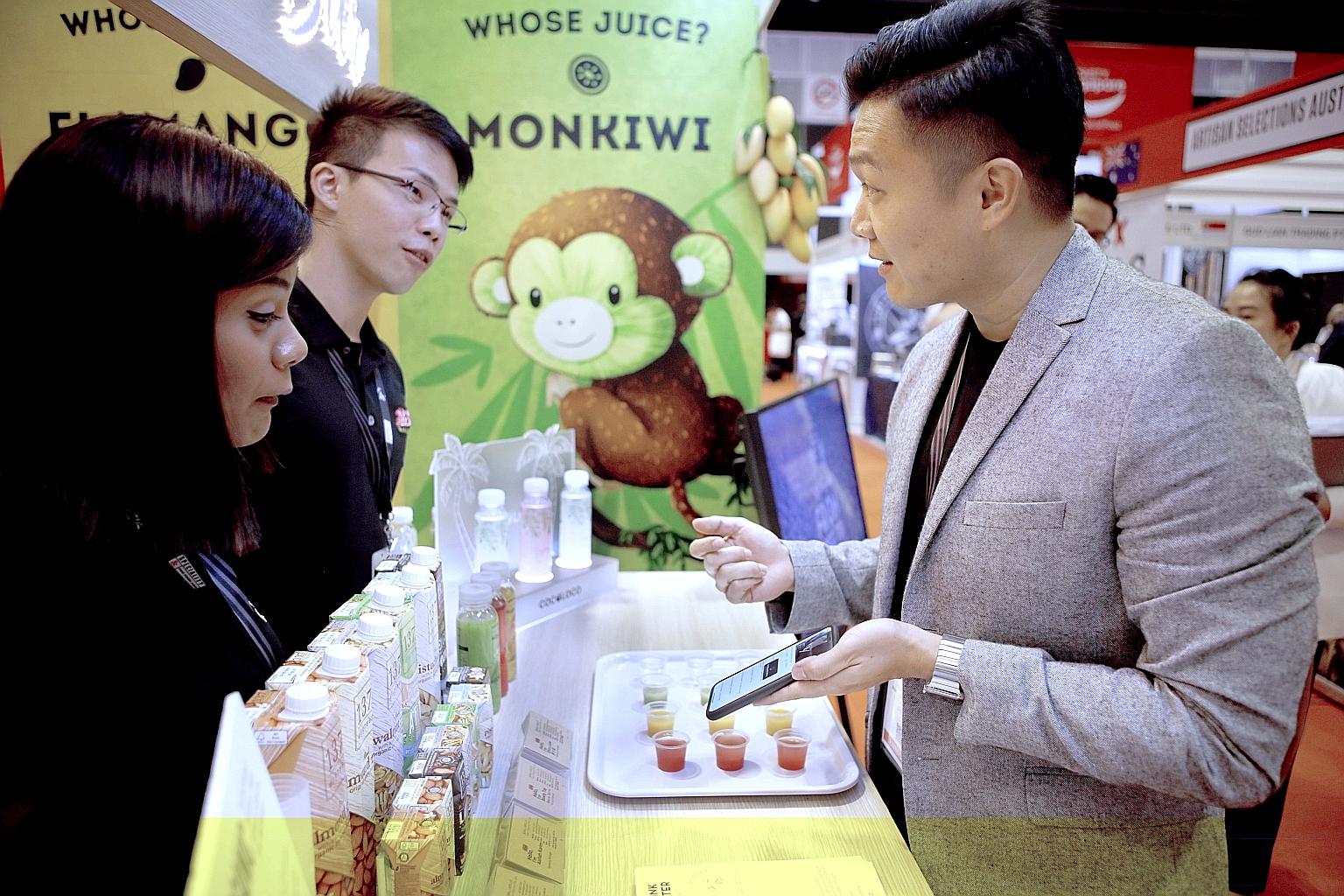 The founder of Whose Juice Kelvin Ngian (right) with his staff Asshah Karim (left) and Elton Liaw. Mr Ngian's company succeeded in producing bottled coconut juice after about a year of trial and error.