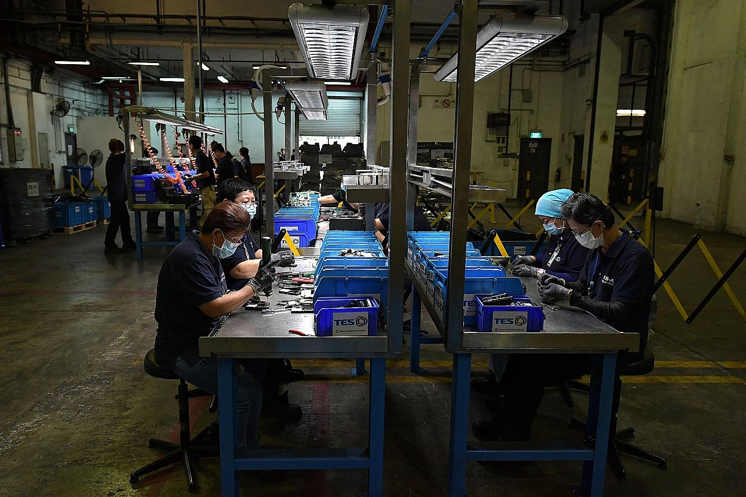 Workers disassembling electronic devices at TES-AMM, one of six main e-waste recycling companies in Singapore. Unlike smaller e-waste, such as computers and smartphones, the percentage of recoverable and recyclable materials for large household appli