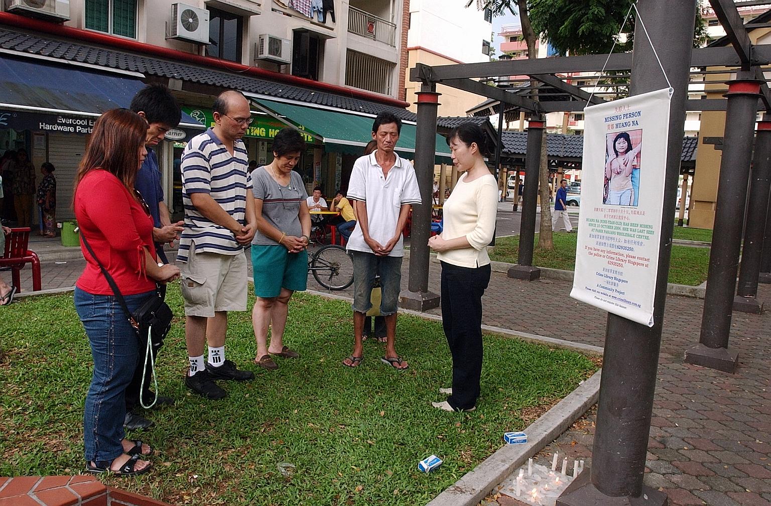 Volunteers who had been searching for Huang Na saying a prayer for her following news that the eight-year-old girl had been found dead in October 2004.