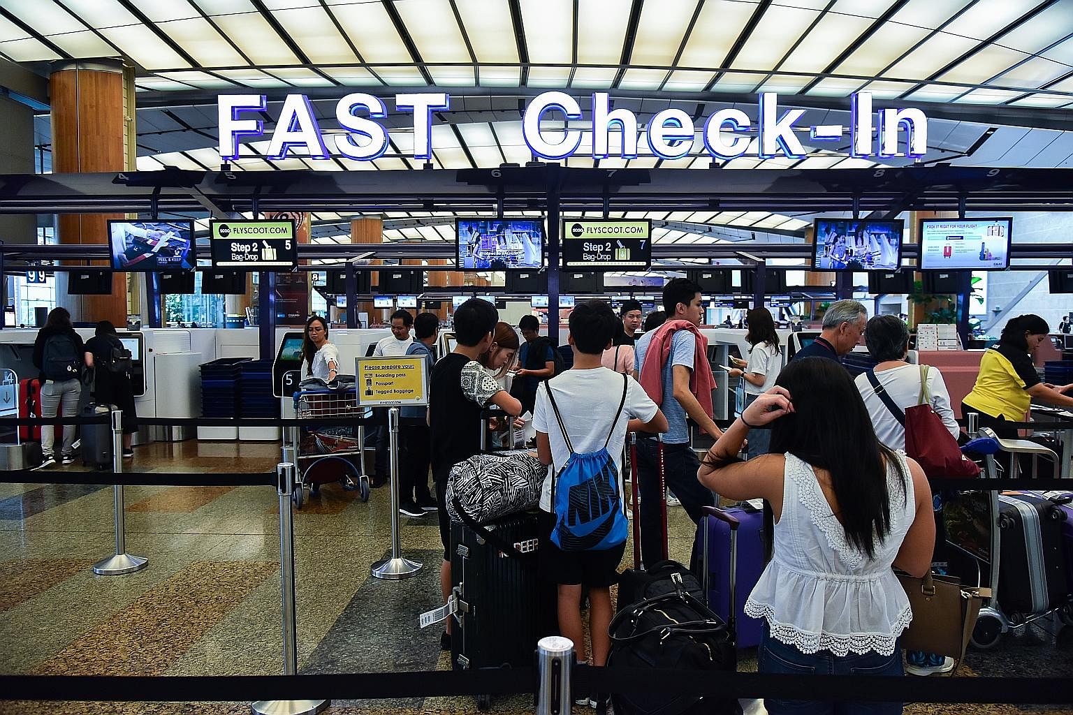 A cluster of check-in and bag-drop counters has been created for Scoot passengers at Terminal 2, in the latest roll-out. Above: A self-service machine for passengers at Changi Airport. Right: So far, 16 airlines have adopted Changi's Fast and Seamles